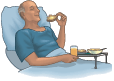 Picture of male patient in bed eating a bagel