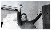 exercise stretcher looped over the bed trapeze arms pulling the stretcher down