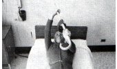 holding cane with weights attached straight over body 
