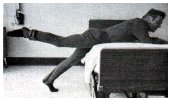leaning on bed with 3 pound weight attached to one ankle raising the leg