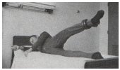 raising the leg while lying on bed with weight attached to ankle 