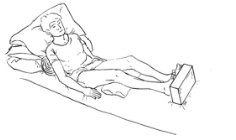 person lying in bed propped up by pillows under shoulders and legs